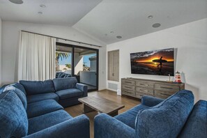Ein modernes Wohnzimmer mit Sofa, Couchtisch und einem Sonnenuntergangsbild.