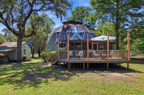 Eine Holzhütte mit einer Terrasse, umgeben von Bäumen.
