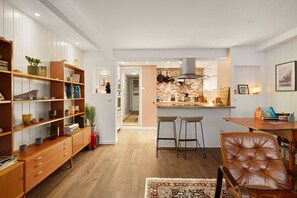 Una cocina moderna con armarios de madera, una isla central y taburetes de bar.
