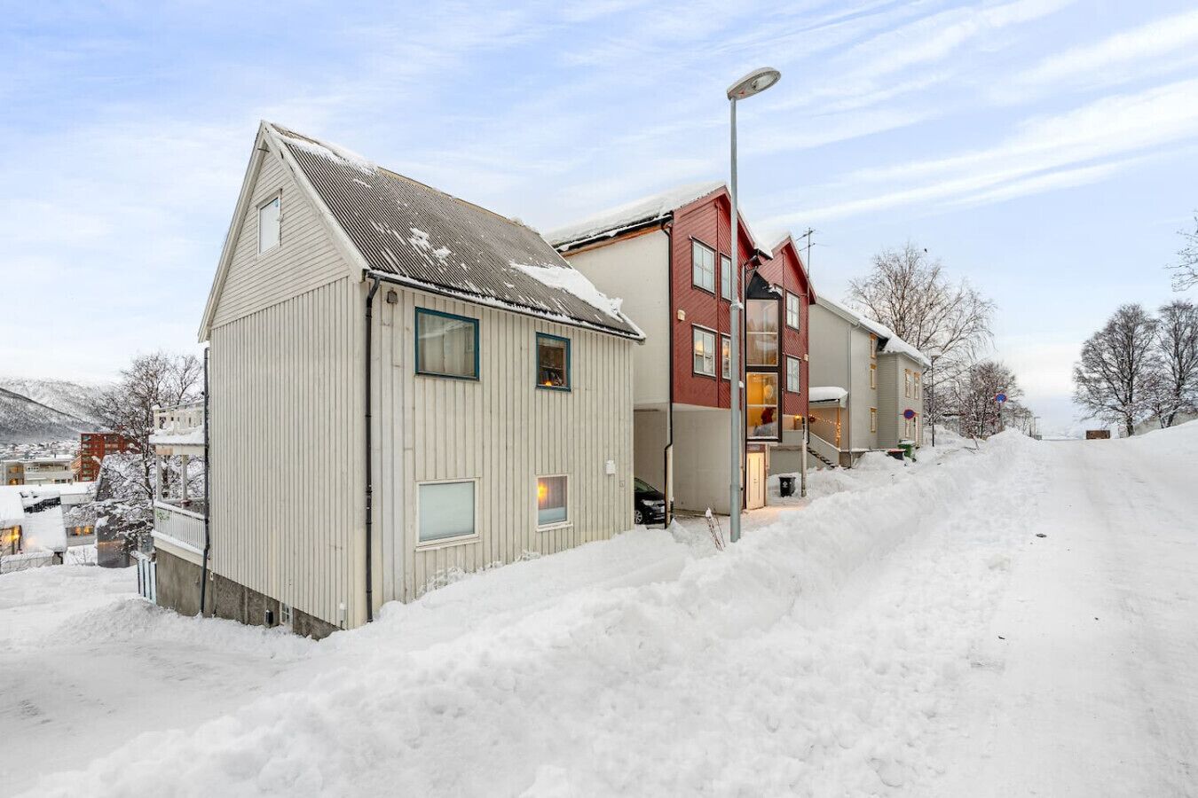 Uma área residencial com casas, uma rua e uma paisagem coberta de neve.