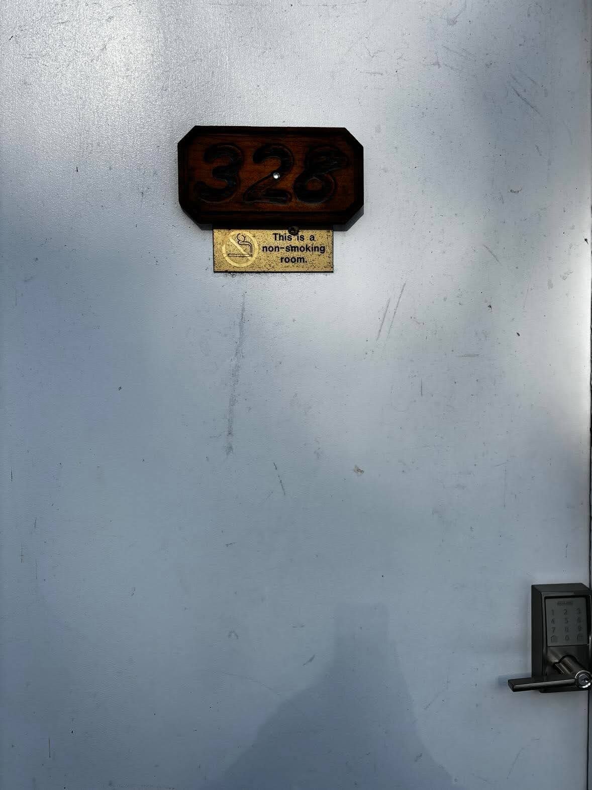 Ein Rauchverbot-Schild an einer Wand mit einem Türschloss und einem Zahlencode-Feld.