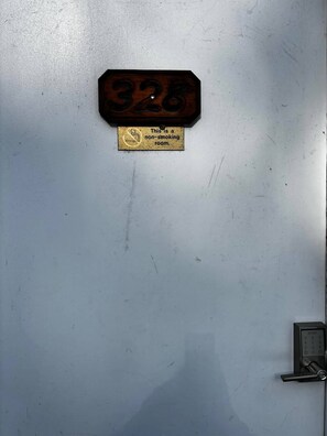 Ein Rauchverbot-Schild an einer Wand mit einem Türschloss und einem Zahlencode-Feld.
