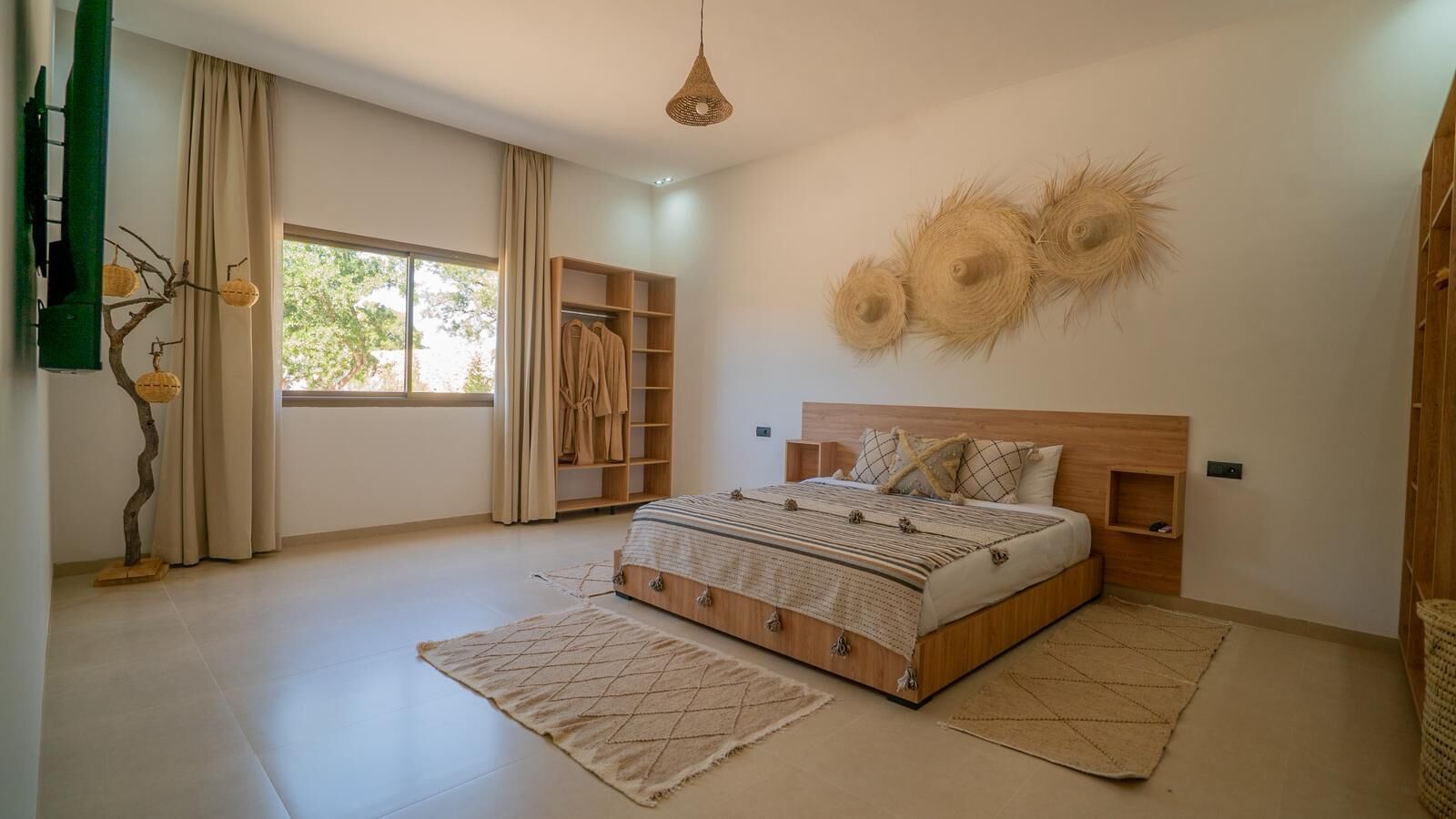 Une chambre à coucher avec un lit, une armoire, une fenêtre et un luminaire suspendu.