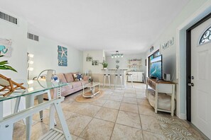 A spacious living area with a sofa, coffee table, and a television. - SummerSalt - 5 Min Walk To Beach! (Jupiter)