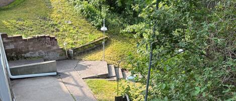 A pathway leading to a grassy area with a metal railing and a lamp post.