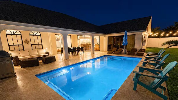 Ein Swimmingpool mit Liegestühlen und einer Terrassenfläche.