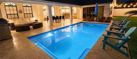 Una piscina con sillas de descanso y una zona de terraza.