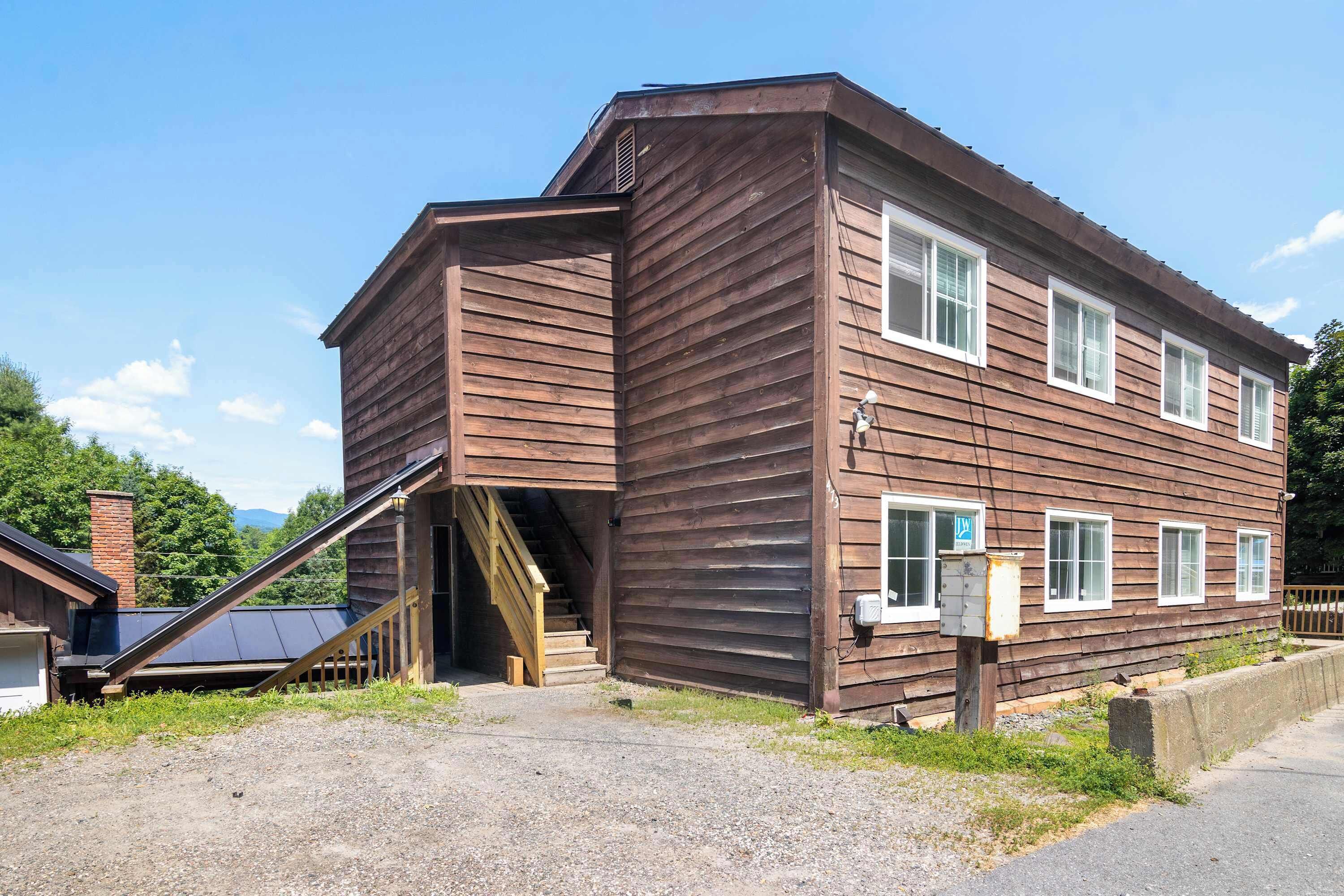 A two-story wooden building with a staircase leading to an upper level.