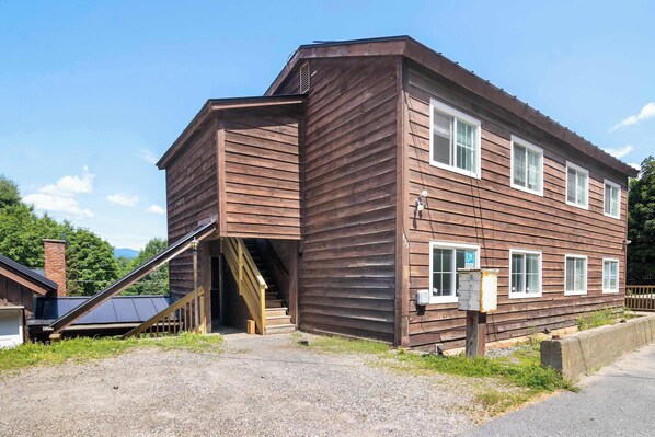 A two-story wooden building with a staircase leading to an upper level.