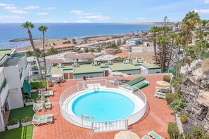 Ein Pool auf dem Dach mit Blick auf Strand und Meer.