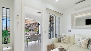 Ein modernes Wohnzimmer mit einer Couch, einem Couchtisch und einem Essbereich mit Stühlen und einem Tisch.