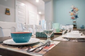 A dining table set with plates, a glass, and a blue bowl.