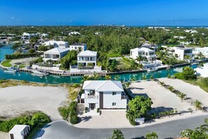 A coastal residential area with houses, a marina, and a beach. - Modern Canal-front Villa in Leeward (Leeward Settlement)