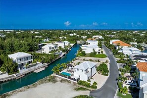 A coastal residential area with houses, a marina, and a clear view of the ocean. - Modern Canal-front Villa in Leeward (Leeward Settlement)