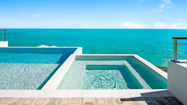 Ein Pool mit klarem Wasser und Blick auf den Ozean.