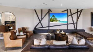 A modern living room with a large flat-screen TV, leather sofas, and a coffee table. - Sleek Miami 2BR | Free parking | Pool & Gym (Miami)