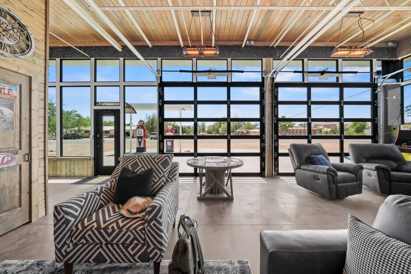 A spacious indoor area with a large window, a round table, and several seating options.