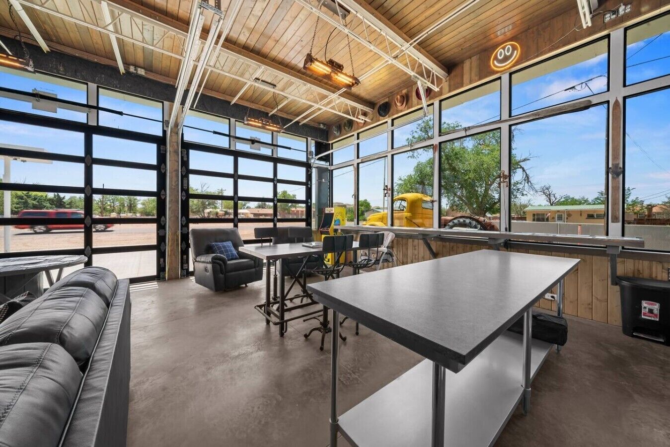 A spacious indoor area with a large table, chairs, and a sofa.
