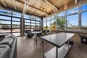 A spacious indoor area with a large table, chairs, and a sofa.