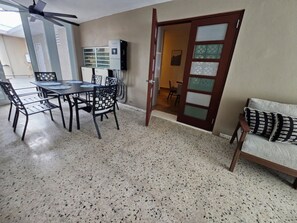 Covered patio with dining set, ceiling fan, and seamless indoor-outdoor access - SJ City Oasis Pool Billiards Power & Water Back up (San Juan)