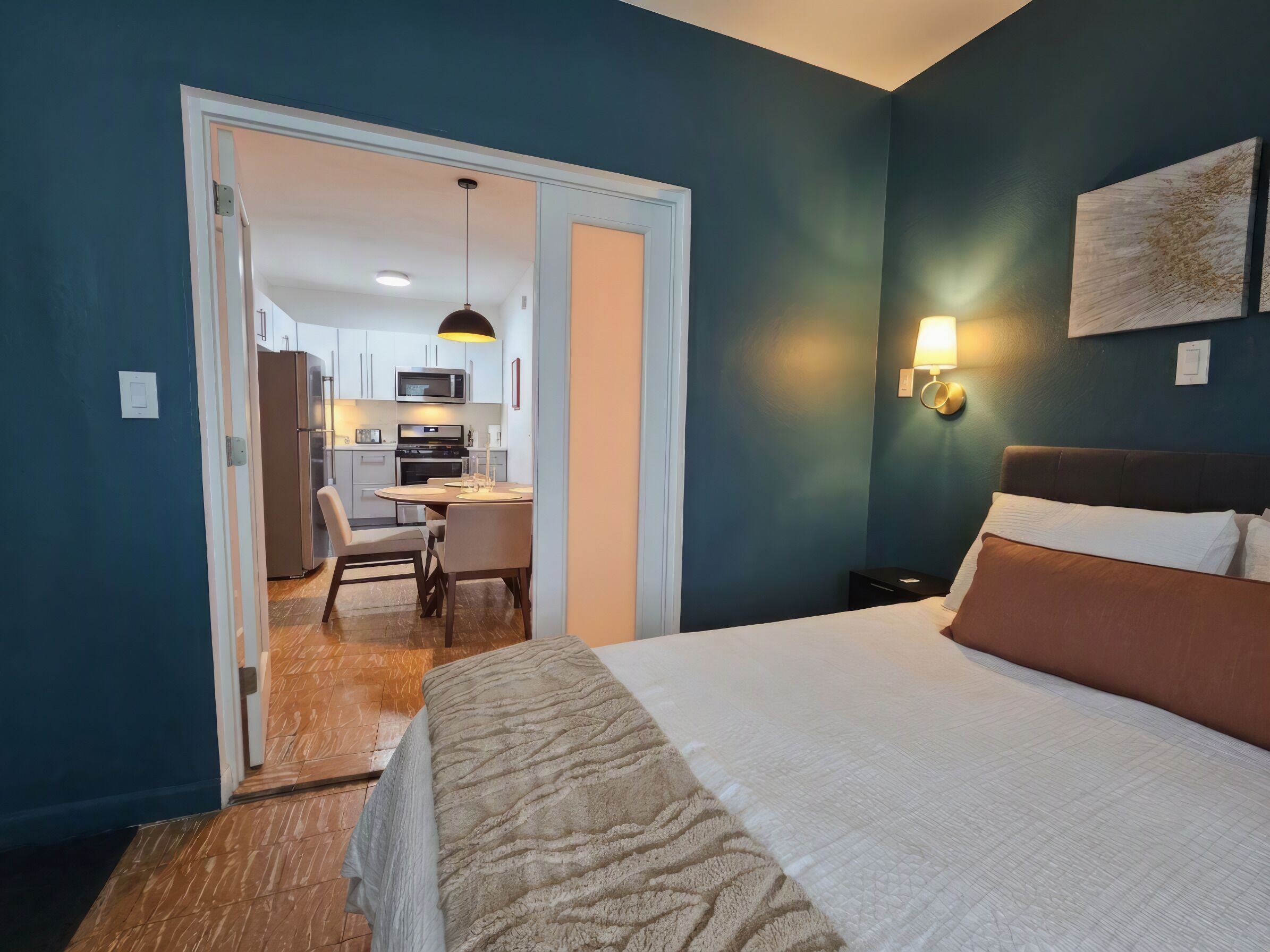 Een hotelkamer met een bed, bureau en kitchenette.