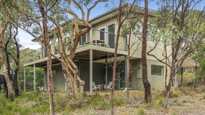 A two-story house with a balcony, surrounded by trees. - Fairhaven Treetops Lookout (Fairhaven)