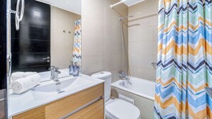 Un baño moderno con ducha, inodoro y lavabo.