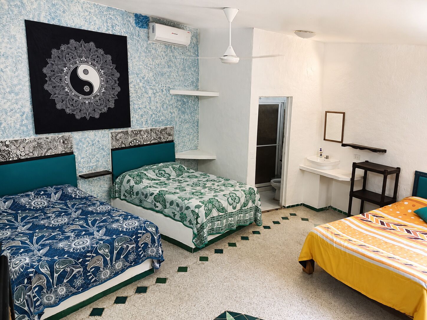 Une chambre avec deux lits, une salle de bain et un petit coin bureau.