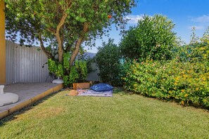 A backyard with a patio, a tree, and a bush with flowers. - Villa Monte Galego. Private pool and garden. A space just for you. (Guia)