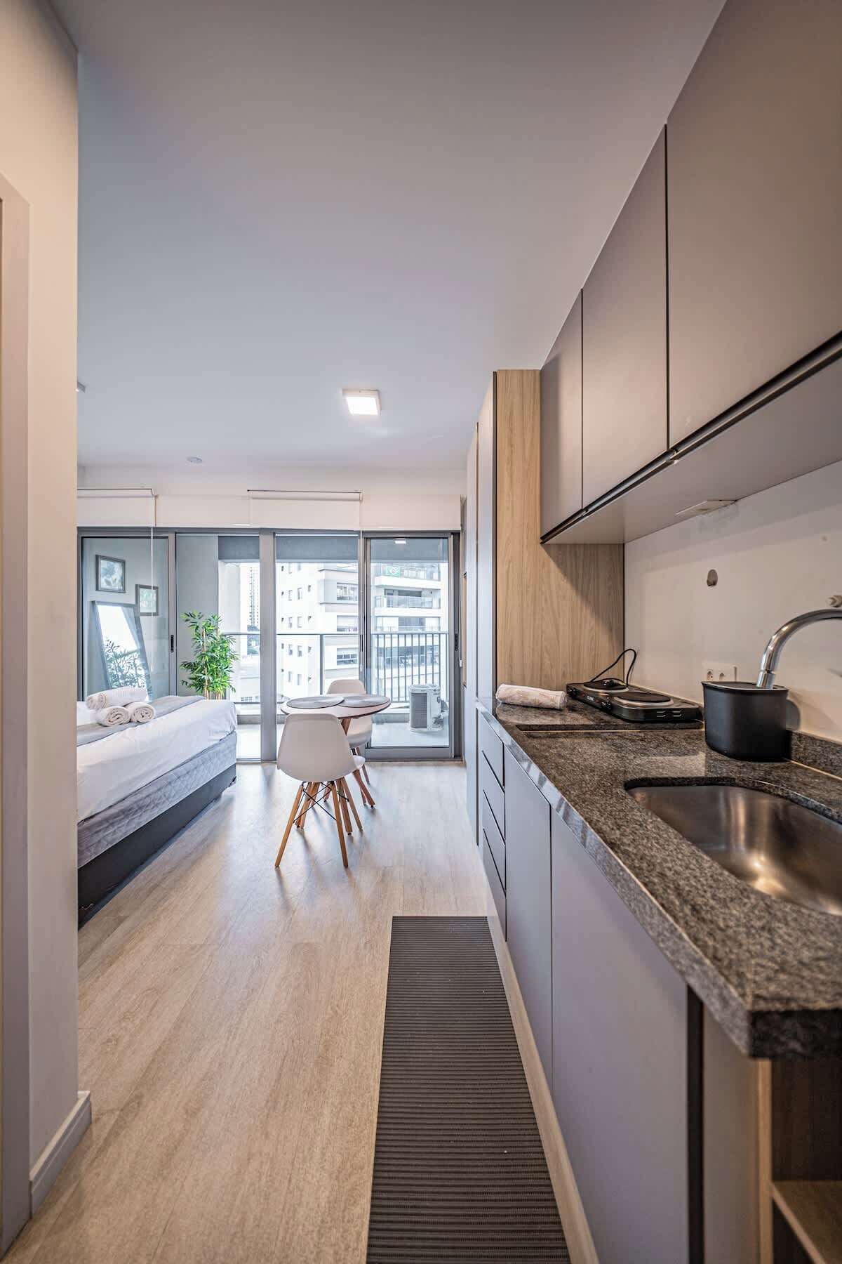 Et moderne køkken med en granitbordplade, indbygget ovn og vask.