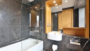 Een moderne badkamer met een bad, een wastafel en een spiegel.