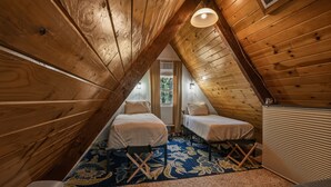 Ein kleines Schlafzimmer im Dachgeschoss mit zwei Betten, einer Heizung und einem Fenster.