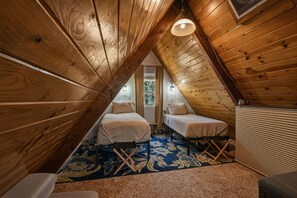 Ein kleines Schlafzimmer im Dachgeschoss mit zwei Betten, einer Heizung und einem Fenster.