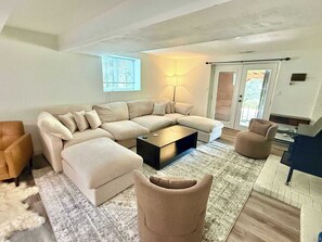 En stue med en modulsofa, et sofabord, et tæppe og en lampe.
