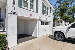 A white building with the number 707 on the corner, a garage, and a parked white SUV. - Midtown Reno Apartment | Workspace Near UNR (Reno)