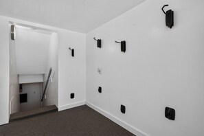 A room with white walls, a carpeted floor, and a door leading to a staircase. - Mt Rose Retreat | Near Midtown & Downtown (Reno)
