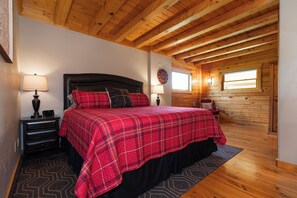 A bedroom with a bed, nightstands, a clock, and a window.