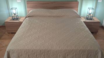 A bed with a textured blanket, wooden headboard, and two bedside tables with lamps.