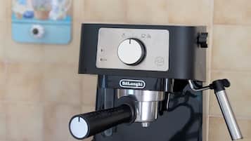 Una máquina de café espresso negra con pantalla digital, vaporizador y portafiltro sobre una encimera.