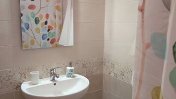 Une salle de bain avec un lavabo blanc, un miroir et des toilettes.