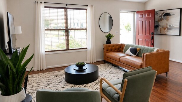 Un salon comprenant un canapé, un fauteuil, une table basse et une plante en pot.