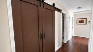 Un couloir doté d’un plancher en bois et d’une porte coulissante.