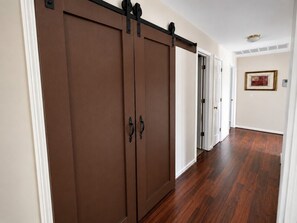 Ein Korridor mit Holzboden und einer Schiebetür.