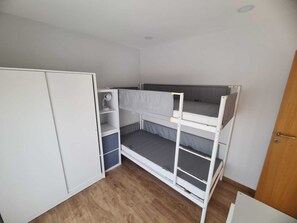A room with a bunk bed, a wardrobe, and a door. - Hibiscus House (Viana do Castelo)