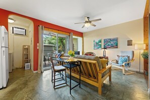 Ein Wohnzimmer mit Sofa, Sesseln, einem Tisch und einem Deckenventilator.