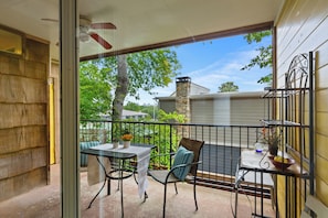 A balcony with a table and chairs, a potted plant, and a view of the surrounding area. - Walk to Zilker & Barton Springs / Old Austin Charm / Private Patio & Parking (Austin)