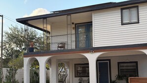 A two-story house with a balcony, a covered porch with columns, and a front door. - Peaceful Poolside Retreat Near Orlando Health.  Resort Style Amenities Workspace (Orlando)