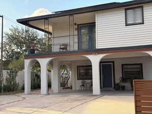 A two-story house with a balcony, a covered porch with columns, and a front door. - Peaceful Poolside Retreat Near Orlando Health.  Resort Style Amenities Workspace (Orlando)
