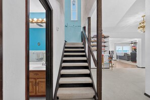 A staircase leading to a living area with a view of the sea, a dining area, and a kitchen. - Beautiful 4-bedroom beach front house in Ponce Inlet (Port Orange)