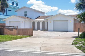 Ein Wohnhaus mit Garage, Auffahrt und Holzzaun.